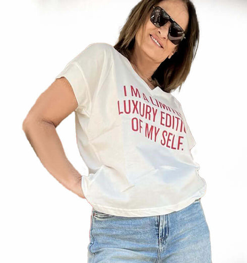 Female model wearing a white cotton V-neck t-shirt with red text saying 'I'm a limited luxury edition of my self'.